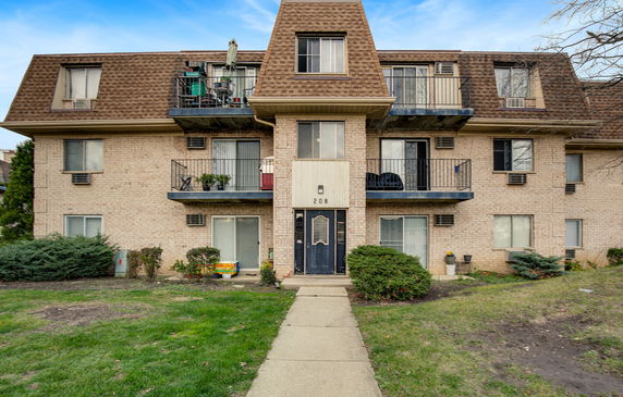 Front view of a multi-story residential building with balconies.