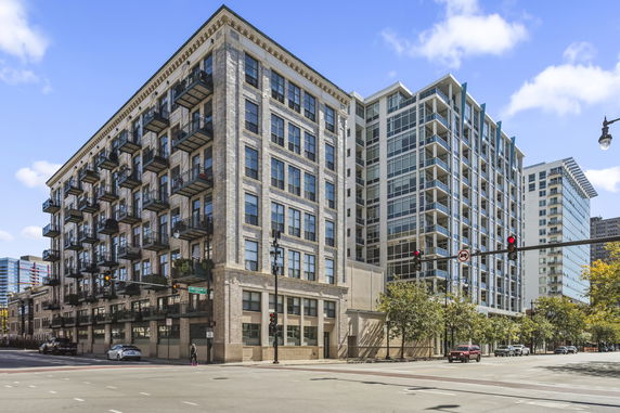 Front view of a multi-story building with numerous balconies and modern architecture.
