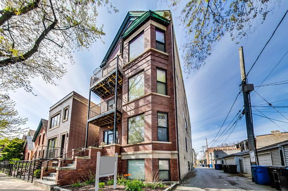 Front view of a multi-story brick building with balconies.