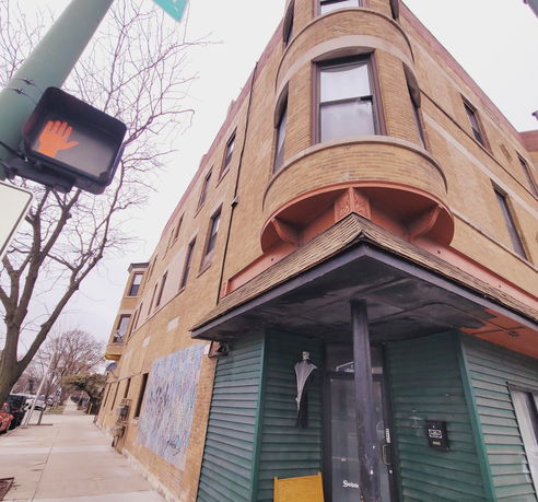 Front view of a multi-story brick building with rounded windows.