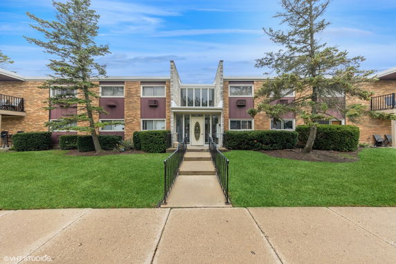 Front view of a two-story building with a central entrance and brick exterior.