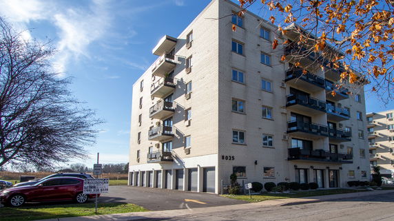 Front view of a multi-story apartment building with balconies.