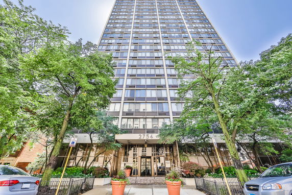 Front view of a high-rise building with multiple windows and a prominent entrance.