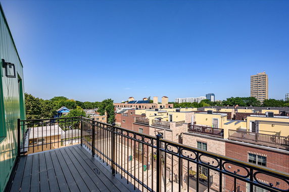 View from a balcony overlooking residential buildings and distant high-rises.