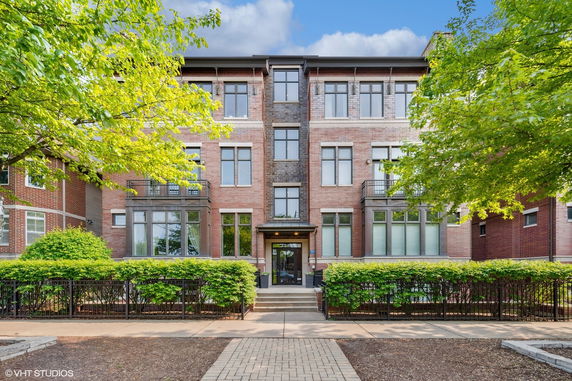 Front view of a multi-story brick building with large windows and a central entrance.