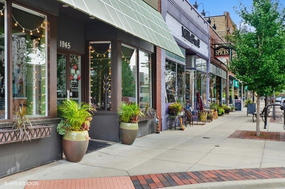 Front view of storefronts with large windows and planters.