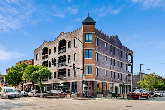 Front view of a multi-story urban building with a corner entrance.