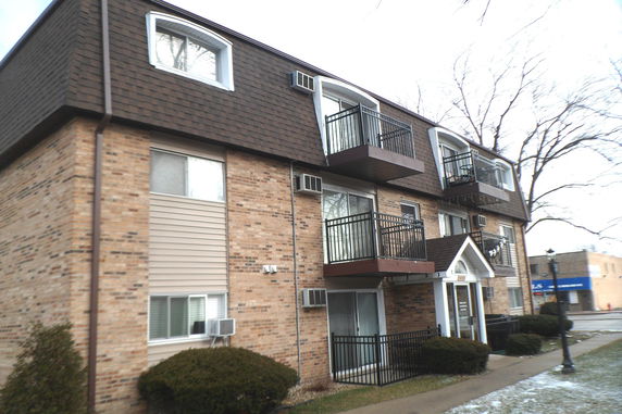 Front view of a multi-story apartment building with balconies.