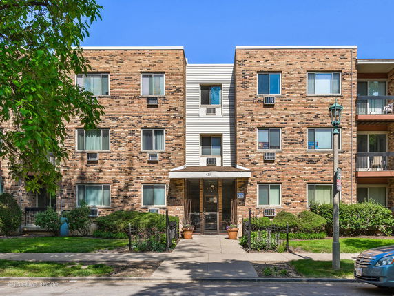 Front view of a multi-story brick apartment building.