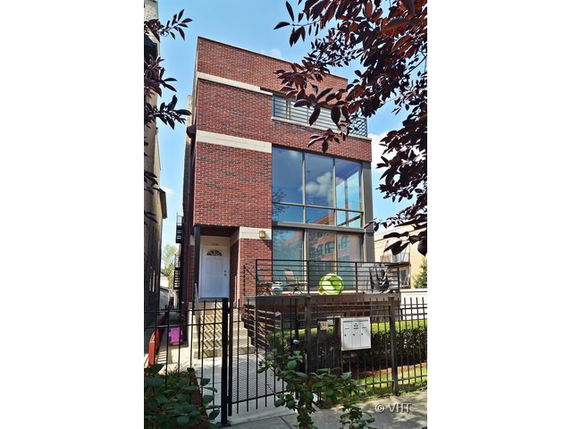 Front view of a modern two-story brick house with large windows.