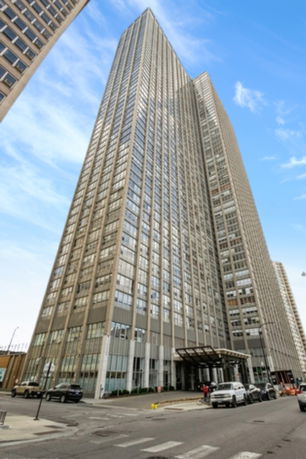 Front view of a tall skyscraper building with numerous windows.