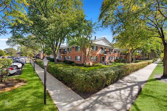 Front view of a two-story brick apartment building with balconies.