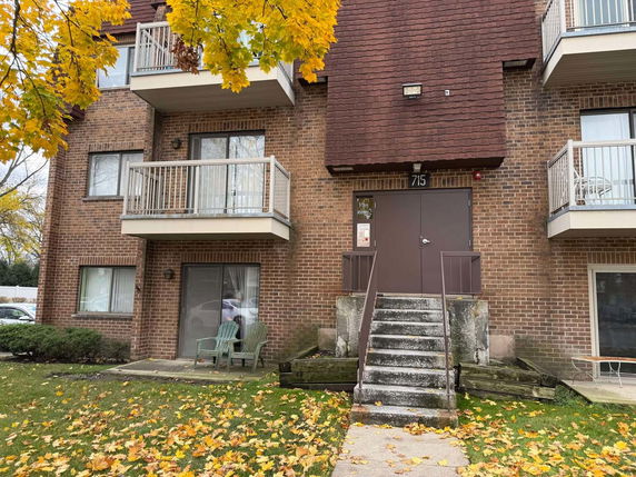 Front view of a multi-story brick building with balconies.