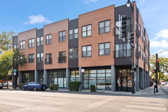 Front view of a multi-story building with retail space on the ground floor.