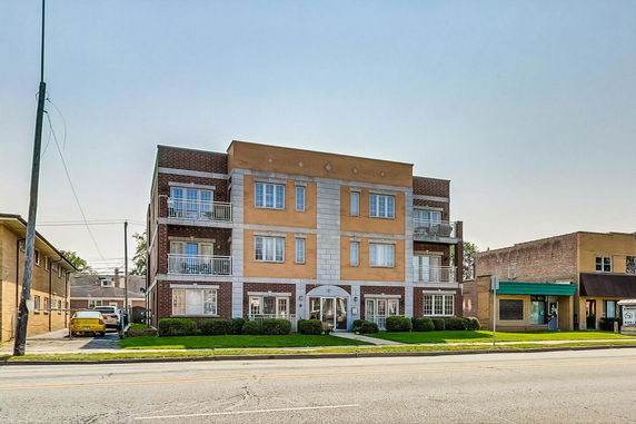 Front view of a three-story apartment building with balconies.