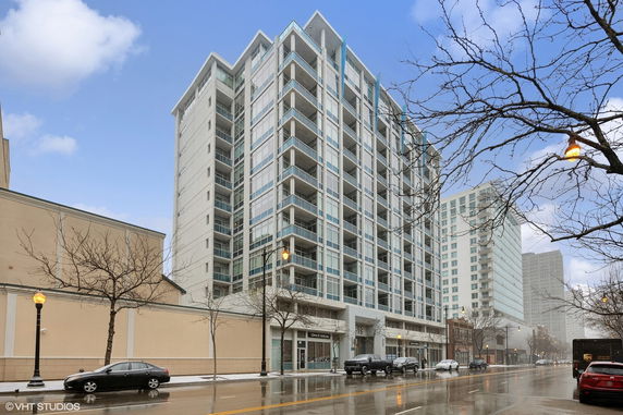 Front view of a multi-story building with glass balconies and modern design.