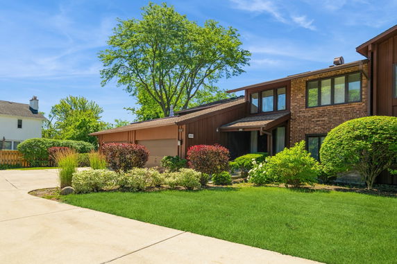 Front view of a two-story house with a landscaped garden and driveway.