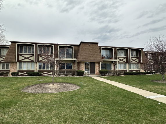 Front view of a two-story residential building with brown and beige exterior.