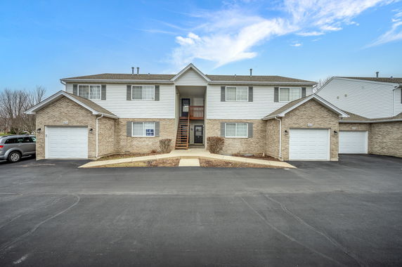 Front view of a two-story residential building with attached garages.