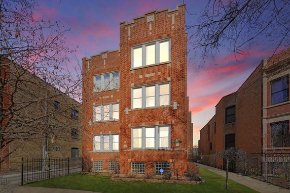 Front view of a brick multi-story building with symmetrical windows.