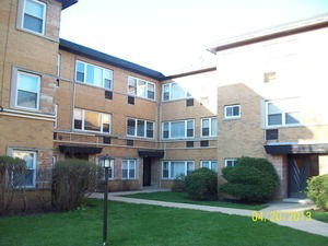 Front view of a multi-story apartment building with brick facade.