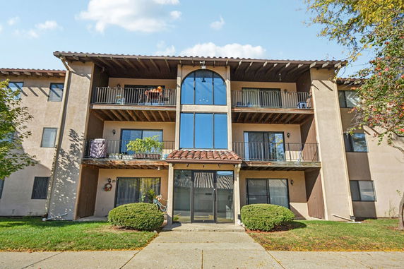 Front view of a multi-story apartment building with balconies.
