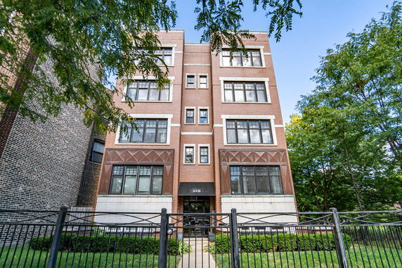 Front view of a multi-story building with a brick facade and multiple windows.