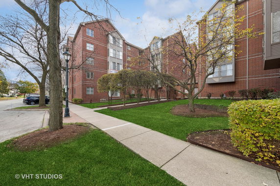 Front view of a multi-story brick building with landscaped pathways.