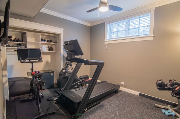 Home gym with exercise equipment including a treadmill and stationary bike.