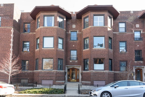 Front view of a multi-story brick apartment building.