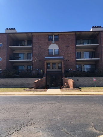 Front view of a three-story brick apartment building.