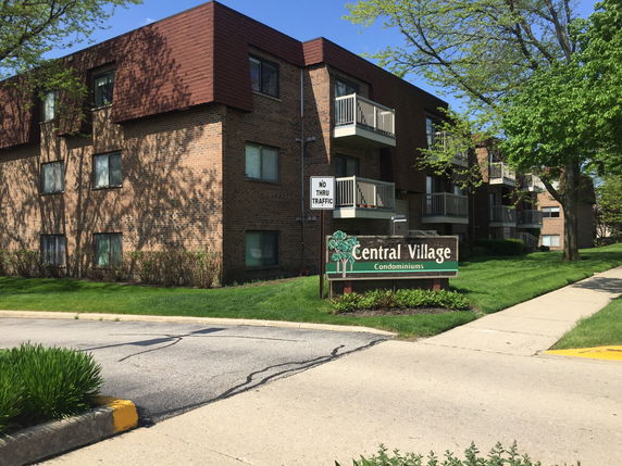 Front view of a multi-story condominium building with balconies.