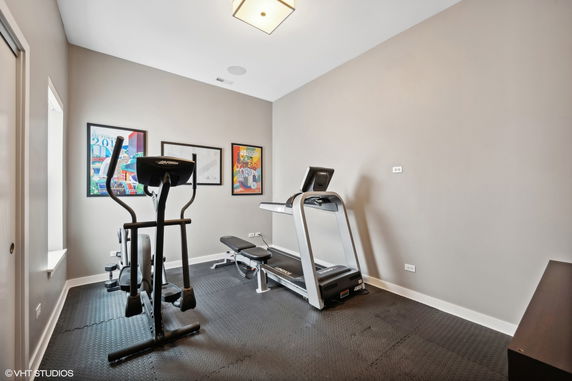 Indoor room equipped with gym equipment including a treadmill and exercise machine.
