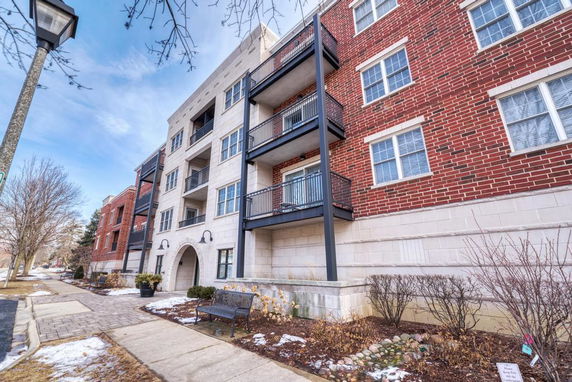 Front view of a multi-story residential building with balconies and red brick exterior.