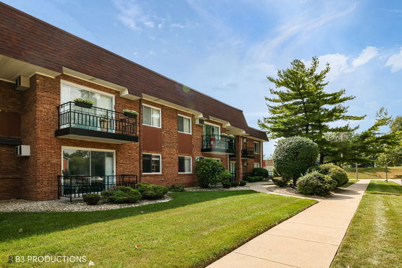 Front view of a two-story brick apartment building with balconies.