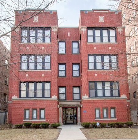 Front view of a four-story brick apartment building.