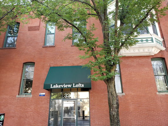 Front view of a brick apartment building with a green awning.