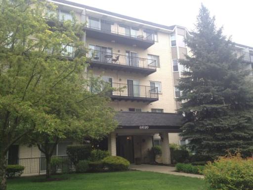 Front view of a multi-story apartment building with balconies.