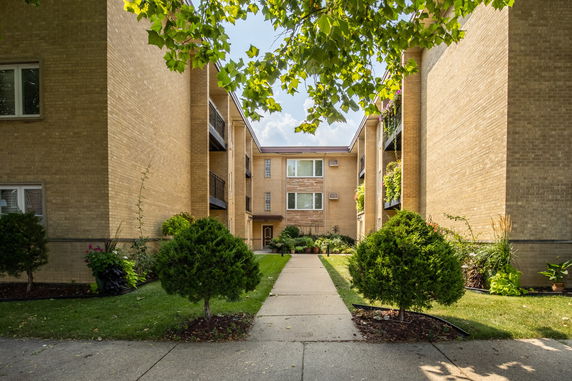 Front view of an apartment complex with brick exterior and balconies.