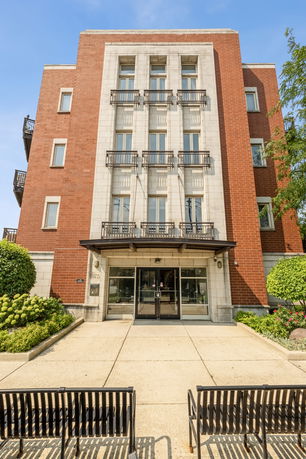 Front view of a multi-story brick and stone building with balconies.