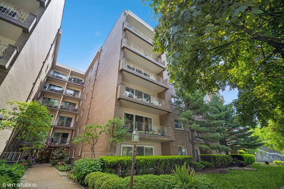 Front view of a multi-story apartment building with balconies.