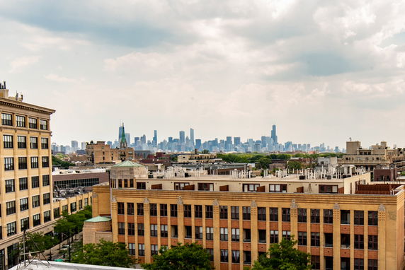 Panoramic view of multi-story buildings with a city skyline in the background.