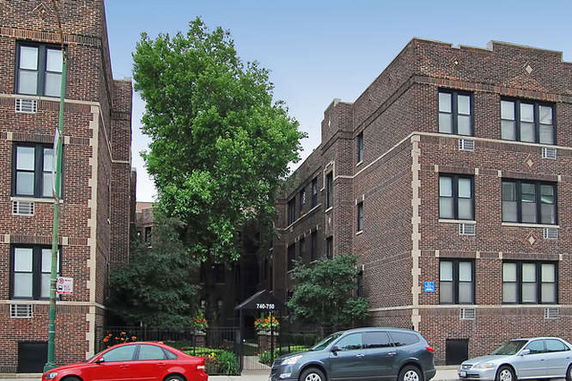 Front view of a brick apartment building with multiple stories.
