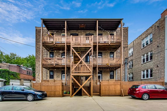 Rear view of a multi-story brick building with wooden balconies.