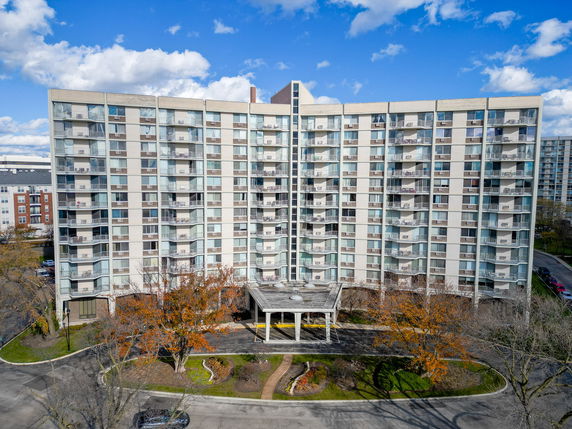 Front view of a multi-story apartment building with balconies.