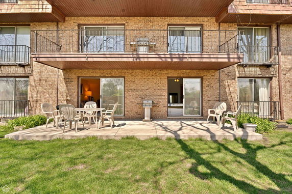 Front view of a multi-story building with balconies and a patio.