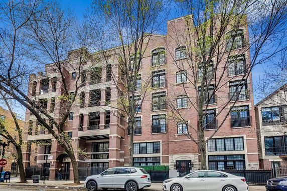 Front view of a multi-story brick building with balconies.