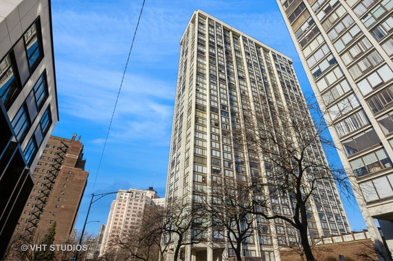View of a tall apartment building with multiple windows in an urban setting.