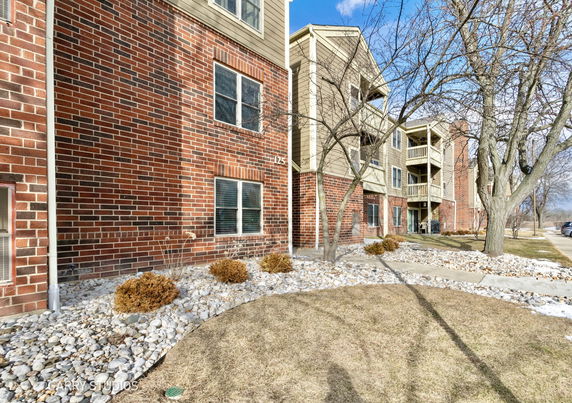 Front view of an apartment building with brick and siding exterior.
