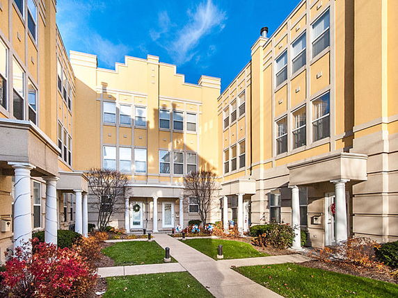 Front view of a multi-story residential building complex with yellow facade.